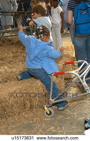 Little girl with a disability, utilizing a walker to assist mobility, bounding to and from her walker to see the animals at the petting zoo. View Large Photo Image Stock Image - Little girl with a disability, utilizing a walker to assist mobility, bounding to and from her walker to see the animals at the petting zoo.. Fotosearch