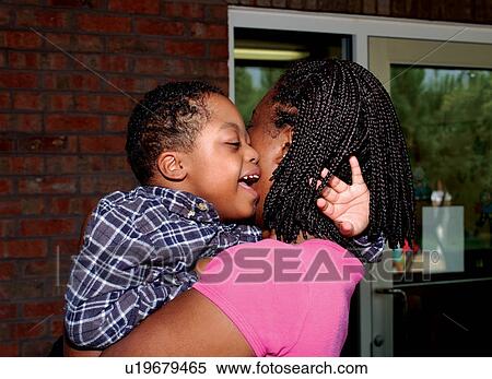 Stock Photography - Woman holding a cute, happy little boy who has disabilities.. Fotosearch