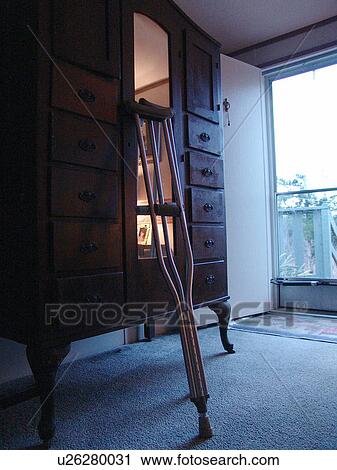 A pair of crutches lean on a piece of furniture. View Large Photo Image Stock Image - A pair of crutches lean on a piece of furniture.. Fotosearch