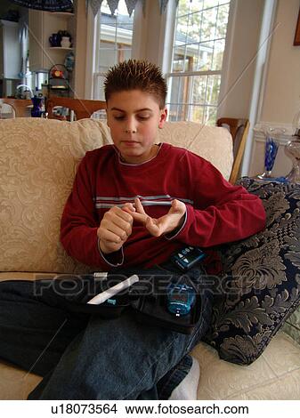 A young boy takes his daily insulin test. View Large Photo Image Picture - A young boy takes his daily insulin test.. Fotosearch