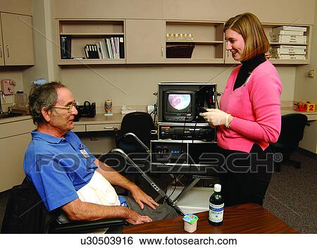 Man with a disability receiving medical treatment from a medical assistant View Large Photo Image Stock Photograph - Man with a disability receiving medical treatment from a medical assistant. Fotosearch