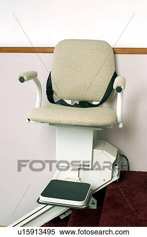 Stock Photography - Powered lift chair that carries a person with mobility impairments up and down stairs.. Fotosearch