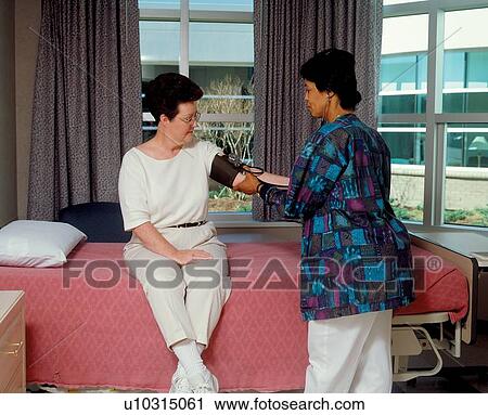 Stock Image - Woman with a disability receiving a routine health exam during her stay at a rehabilitation facility.. Fotosearch