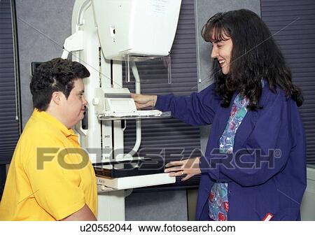 Woman with a disability undergoing a routine physical exam preparing to have a mammogram. Technician is explaining the procedure. View Large Photo Image Picture - Woman with a disability undergoing a routine physical exam preparing to have a mammogram. Technician is explaining the procedure.. Fotosearch
