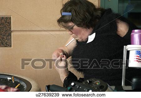 Woman with multiple physical disabilities using her toes to light her cigarette. View Large Photo Image Stock Photo - Woman with multiple physical disabilities using her toes to light her cigarette.. Fotosearch
