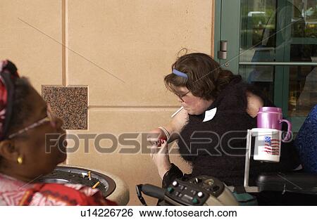 Woman with multiple physical disabilities using her toes to light her cigarette. View Large Photo Image Stock Photograph - Woman with multiple physical disabilities using her toes to light her cigarette.. Fotosearch