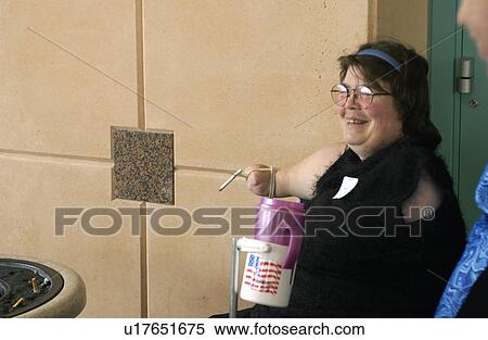 Woman with multiple physical disabilities using an adaptive device to smoke her cigarette. View Large Photo Image Stock Photography - Woman with multiple physical disabilities using an adaptive device to smoke her cigarette.. Fotosearch