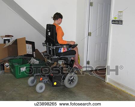 Young woman (electric wheelchair user) heads for the next room. View Large Photo Image Stock Photography - Young woman (electric wheelchair user) heads for the next room.. Fotosearch