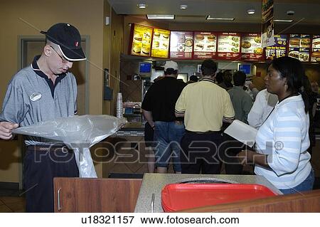 A man with a disability emptying the trash at a fast food restaurant. View Large Photo Image Stock Photo - A man with a disability emptying the trash at a fast food restaurant.. Fotosearch