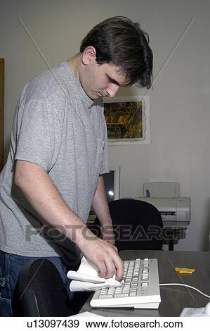 A man with a disability is working in an office cleaning the computer. View Large Photo Image Stock Photo - A man with a disability is working in an office cleaning the computer.. Fotosearch