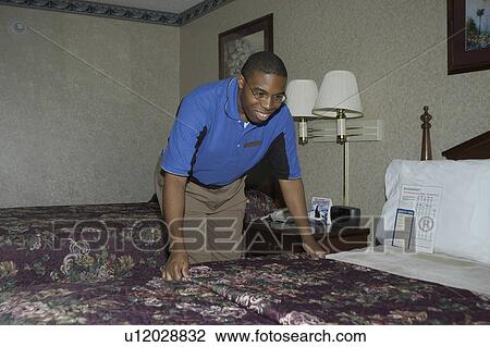 A man working changing the sheets in a hotel room. View Large Photo Image Stock Image - A man working changing the sheets in a hotel room.. Fotosearch