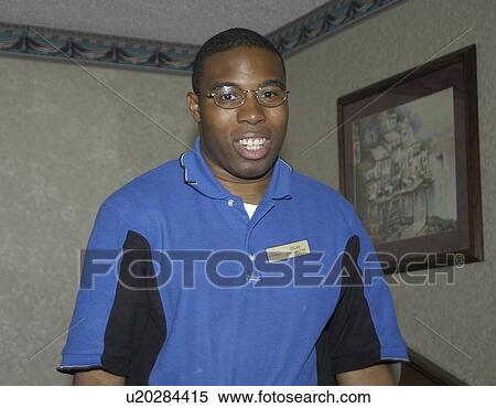 Stock Photography - A man working cleaning a hotel room.. Fotosearch