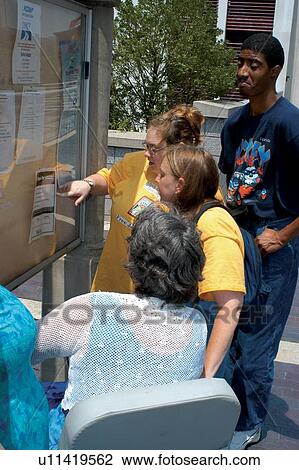 Four individuals with disabilities navigating through a large city via a directory to guide them along their way. View Large Photo Image Stock Image - Four individuals with disabilities navigating through a large city via a directory to guide them along their way.. Fotosearch