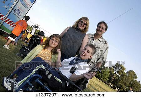 Diagonal view of a boy with a disability and his family having a good time in the park. View Large Photo Image Stock Image - Diagonal view of a boy with a disability and his family having a good time in the park.. Fotosearch