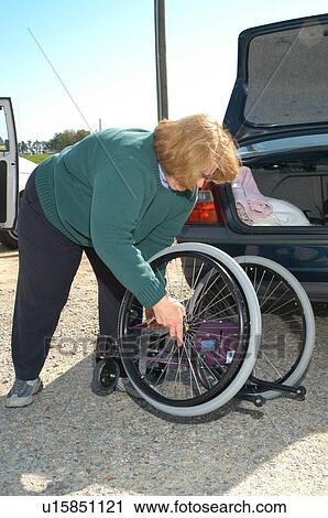 Grandmother putting together a wheelchair to provide mobility for her granddaughter. View Large Photo Image Stock Image - Grandmother putting together a wheelchair to provide mobility for her granddaughter.. Fotosearch