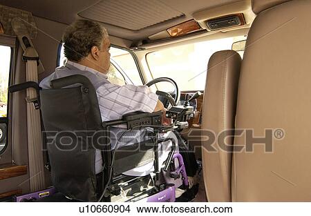 Picture - Man utilizing a wheelchair for mobility driving a van modified with hand controls.. Fotosearch