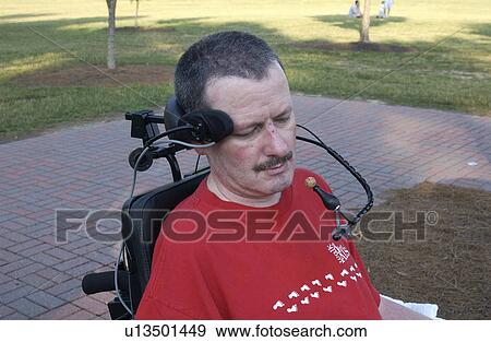 Man with a disability utilizing a mouthpiece to maneuver his wheelchair. View Large Photo Image Stock Photo - Man with a disability utilizing a mouthpiece to maneuver his wheelchair.. Fotosearch