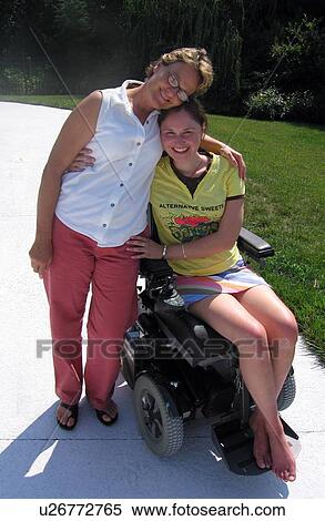 Mom gives daughter (electric wheelchair user) a hug for the camera. View Large Photo Image Stock Photography - Mom gives daughter (electric wheelchair user) a hug for the camera.. Fotosearch