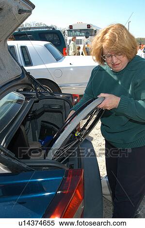 Woman removing wheelchair from car to provide mobility for her child. View Large Photo Image Stock Photography - Woman removing wheelchair from car to provide mobility for her child.. Fotosearch