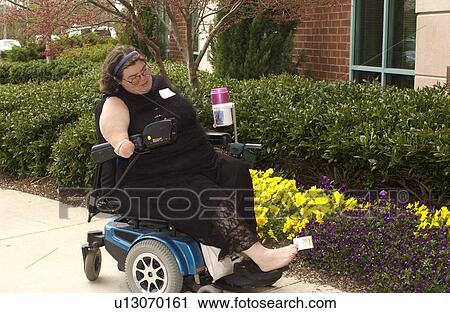 Woman with a disability utilizing a powered wheelchair for mobility, carrying her pack of cigarettes with her toes. View Large Photo Image Stock Image - Woman with a disability utilizing a powered wheelchair for mobility, carrying her pack of cigarettes with her toes.. Fotosearch