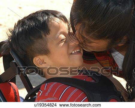Picture - Adorable picture of a boy in a wheelchair kissing his mother.. Fotosearch