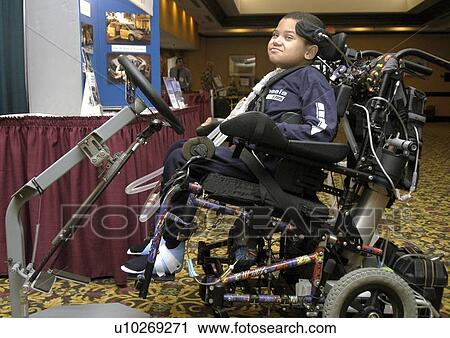 African American boy with tracheotomy breathing tubes and a leg splint exploring display booths at a conference while sitting in his electric wheelchair. View Large Photo Image Stock Image - African American boy with tracheotomy breathing tubes and a leg splint exploring display booths at a conference while sitting in his electric wheelchair.. Fotosearch