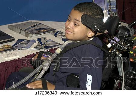 Little boy with significant disabilities looking at various textbooks on display at a conference. View Large Photo Image Stock Photo - Little boy with significant disabilities looking at various textbooks on display at a conference.. Fotosearch