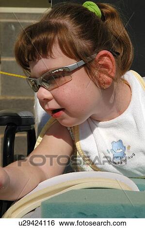 Stock Photograph - Little girl with a disability enjoying some time with her family at an event.. Fotosearch
