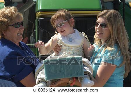 Little girl with a disability having a blasting with her grandmother during an outing. View Large Photo Image Picture - Little girl with a disability having a blasting with her grandmother during an outing.. Fotosearch