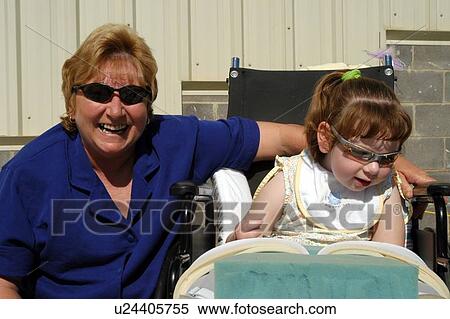 Little girl with a disability spending time with her grandmother at a family function. View Large Photo Image Stock Photography - Little girl with a disability spending time with her grandmother at a family function.. Fotosearch