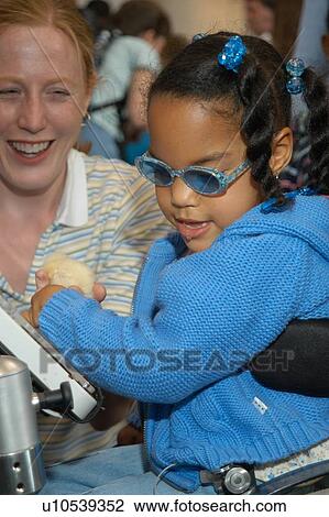 Little girl with a disability - utilizing a wheelchair for mobility and a communication device for expressive language - enjoying some time in the community with a care provider. View Large Photo Image Stock Image - Little girl with a disability - utilizing a wheelchair for mobility and a communication device for expressive language - enjoying some time in the community with a care provider.. Fotosearch