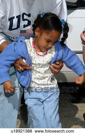 Little girl with disabilities receiving a helping hand to get into her wheelchair. View Large Photo Image Stock Photo - Little girl with disabilities receiving a helping hand to get into her wheelchair.. Fotosearch