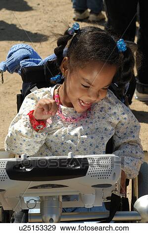 Little girl with multiple disabilities utilizing her communication device to let people know what she wants. View Large Photo Image Stock Photo - Little girl with multiple disabilities utilizing her communication device to let people know what she wants.. Fotosearch