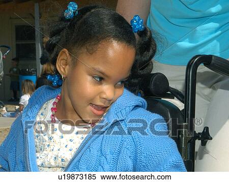 Precious little girl in a wheel chair looking over her shoulder. View Large Photo Image Stock Photography - Precious little girl in a wheel chair looking over her shoulder.. Fotosearch