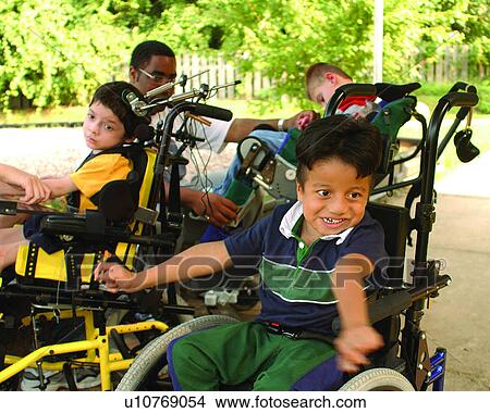 Three adorable little boys with multiple disabilities preparing for an activity at their developmental day center. View Large Photo Image Picture - Three adorable little boys with multiple disabilities preparing for an activity at their developmental day center.. Fotosearch