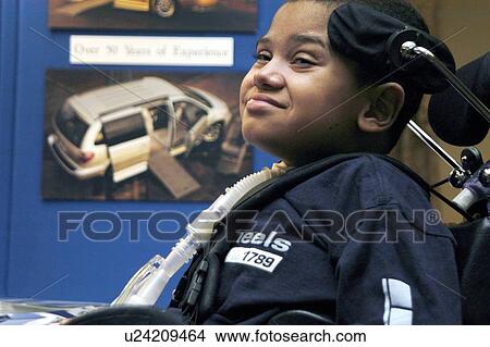 Picture - Young boy with significant disabilities getting around in the community with help from cutting edge assistive technology.. Fotosearch