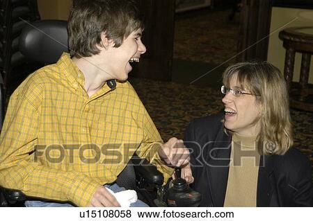 Stock Photo - Young man with significant disabilities spending time with a friend.. Fotosearch