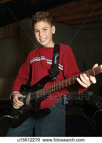 Stock Photo - A young boy with diabetics, jams on his guitar.. Fotosearch