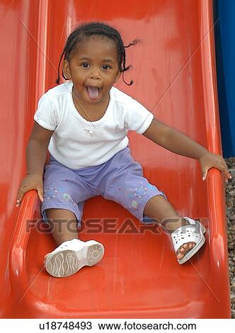 Absolutely adorable image of a little girl with a disability as she comes down a slide. View Large Photo Image Stock Image - Absolutely adorable image of a little girl with a disability as she comes down a slide.. Fotosearch