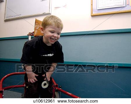 Adorable little boy with a disability learning to use his walker to navigate the halls at his school. View Large Photo Image Stock Image - Adorable little boy with a disability learning to use his walker to navigate the halls at his school.. Fotosearch