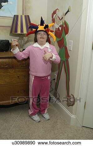 Girl with Down Syndrome clowning around pretending to be a jester. View Large Photo Image Stock Image - Girl with Down Syndrome clowning around pretending to be a jester.. Fotosearch