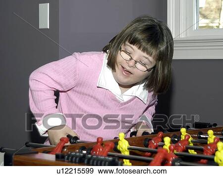 Stock Photo - Girl with Down Syndrome playing ôfoozballö.. Fotosearch