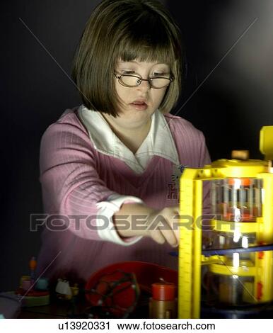 Stock Image - Girl with Down Syndrome playing with toys.. Fotosearch