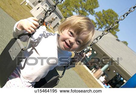 Isn't she absolutely precious! This adorable little girl is having a blast swinging during recess. View Large Photo Image Stock Photography - Isn't she absolutely precious! This adorable little girl is having a blast swinging during recess.. Fotosearch
