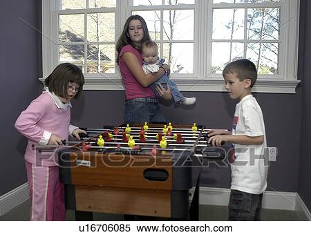 Little boy and a girl with Down Syndrome playing a game of ôfoozballö. View Large Photo Image Stock Photography - Little boy and a girl with Down Syndrome playing a game of ôfoozballö.. Fotosearch