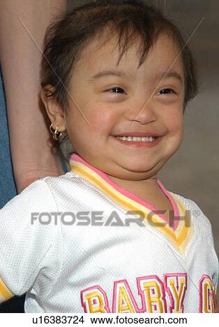 Picture - Little girl, of Hispanic origin, with Downs Syndrome smiling for the camera.. Fotosearch