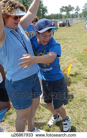 Stock Image - Teenage boy with DownÆs Syndrome thrilled to have won his game.. Fotosearch