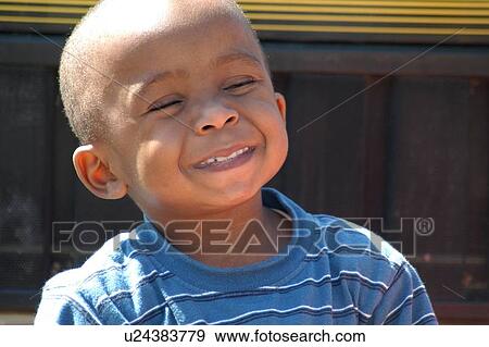 Stock Photo - The smiling face of a child, who just happens to have a disability, while having fun at an event with his friends and family.. Fotosearch