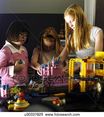 Three children, one with Down Syndrome, playing with toys. View Large Photo Image Stock Photo - Three children, one with Down Syndrome, playing with toys.. Fotosearch