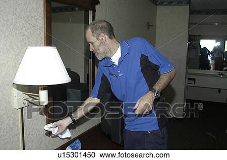 A man dusting in a hotel room. View Large Photo Image Stock Image - A man dusting in a hotel room.. Fotosearch